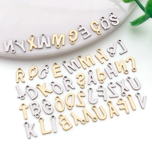 Detailed flat lay of gold and silver stainless steel A-Z alphabet charms for DIY jewelry