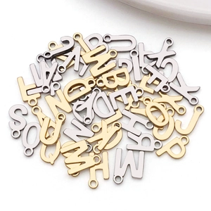 Macro detail of gold and silver lowercase letter charms with loops for DIY jewelry making