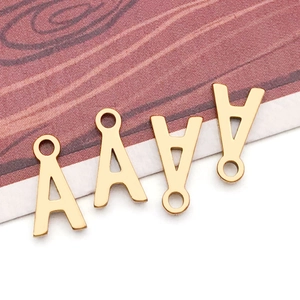 Macro shot of four golden lowercase letter A pendants for DIY jewelry making and crafts