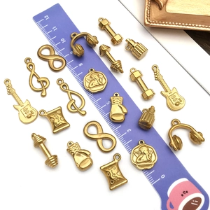 Gold-plated stainless steel charms set with guitar, angel, and dumbbell music motifs
