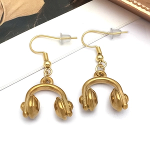 Macro view of gold-plated headphone dangle earrings with silicone stoppers