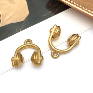 Macro detail of matte gold headphone pendant charms for DIY jewelry accessories