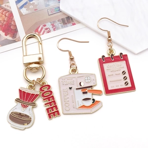 Detail view of coffee-themed alloy charm set with red enamel finish on marble background