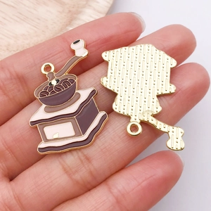 Detailed view of coffee grinder pendants in gold alloy with brown enamel finish