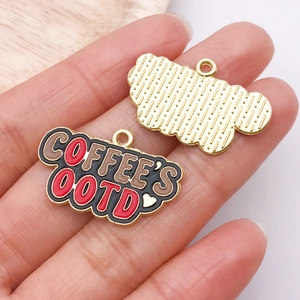 Detail showing front and back of enamel coffee charm with COFFEE'S OOTD lettering