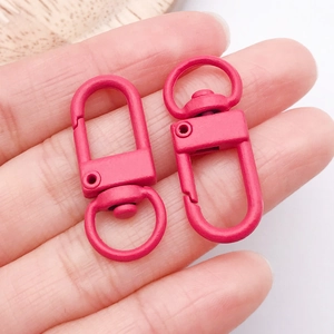 Close-up of matte magenta alloy lobster clasps with rotating rings for DIY jewelry