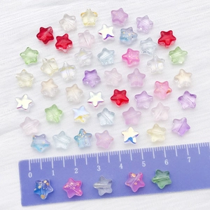 Macro shot of colorful star-shaped glass beads for jewelry making with scale ruler reference
