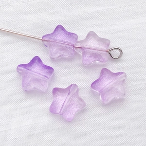 Macro shot of purple gradient star-shaped glass beads for DIY jewelry making