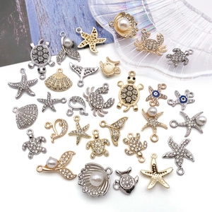 Macro detail of alloy ocean charms with rhinestones including starfish and turtles