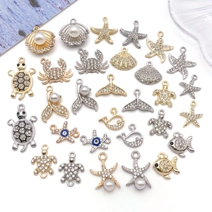Detailed close-up of crystal-encrusted marine alloy charms like seahorse and turtle