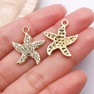 Detail of gold starfish charms featuring pave-set rhinestones and hammered metal texture