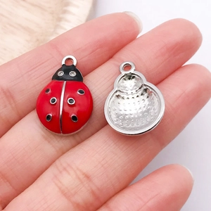 Vue macro détaillée de breloques coccinelles en main pour bijoux DIY