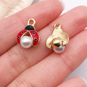 Détail macro du pendentif coccinelle en émail et de l'éventail ondulé avec perles