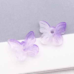 Détail de perles papillon en verre dégradé violet avec trou central pour bijoux DIY