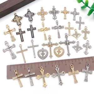 Detail of vintage rhinestone cross pendants in gold and silver with size measurement ruler