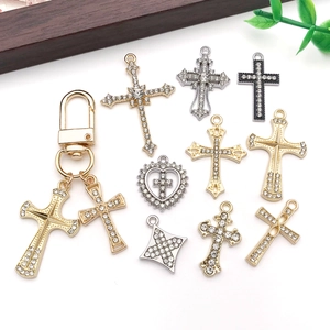 Macro view of crystal-encrusted alloy cross pendants in gold, silver and gun black tones