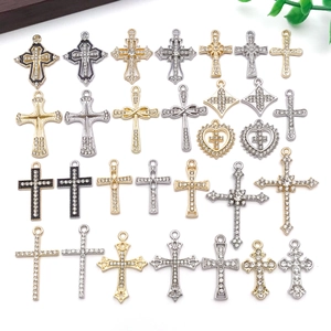 Detailed flat lay of diamond-encrusted vintage alloy cross pendants in gold and silver