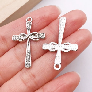 Macro detail of silver rhinestone cross pendant showing front crystals and back texture