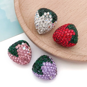 Vista dettagliata di perline a fragola fatte a mano con strass luccicanti in quattro colori