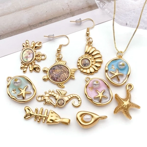 Marine jewelry set with shell crab and starfish charms in gold finish on white background