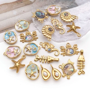 Macro shot of assorted gold sea charms with abalone shell, pearls and enamel detailing