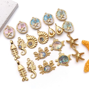 Detailed close-up of ocean-themed stainless steel charms with pearls and sea life shapes