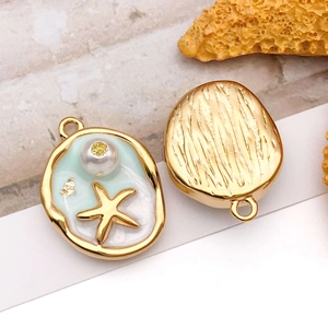 Detail of gold crab pendant with blue enamel, white pearl and golden starfish