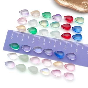 Gros plan de perles goutte d'eau en verre 6x9mm avec règle pour l'échelle