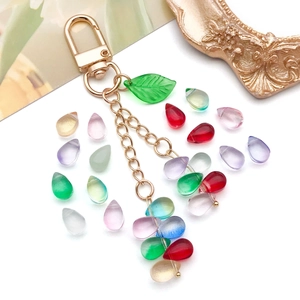 Porte-clés gouttes de cristal coloré avec fermoir doré et décoration de feuille verte