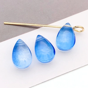 Détail de perles gouttes en verre bleu 6x9mm avec tige dorée pour bijoux faits main