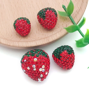 Detailed macro view of 3D crystal strawberry pendants for DIY jewelry and crafts