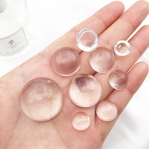 Close-up of various sizes of transparent round dome glass cabochons for DIY crafts