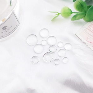 Clear round glass dome cabochons for DIY jewelry making on white silk background