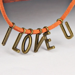 Nahaufnahme der orangefarbenen Wildlederkette mit I LOVE U Anhängern aus Bronze