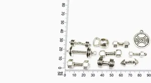 Macro shot of antique silver dumbbell and barbell pendants with measurement scale