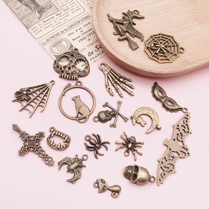 Detailed flat lay of assorted bronze Halloween charms including skulls, bats and spiders