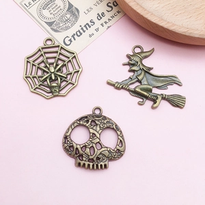 Detailed macro view of vintage bronze Halloween charms including spider webs and witches