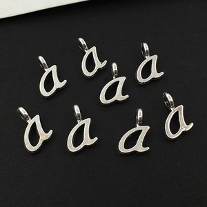 Gros plan de petits pendentifs lettre 'a' argentée en alliage pour création bijoux