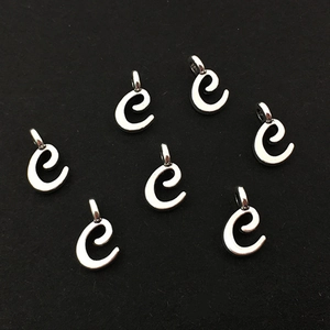 Détail des breloques en forme de lettre 'e' argentées pour création de bijoux
