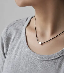 Collier minimaliste cordon noir avec pendentif étoile argenté porté par un mannequin