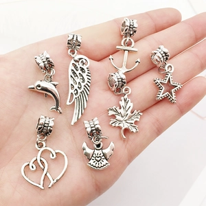 Close-up of seven vintage silver alloy charms with intricate star and heart details