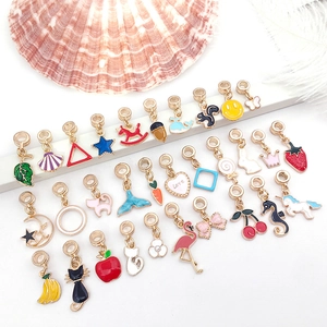 Macro detail of various colorful alloy charms with gold coating on a clean white display