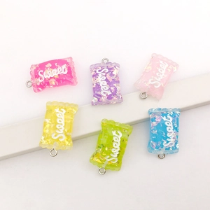 Colorful resin candy charms with Sweet text and glitter on white tiered display stand