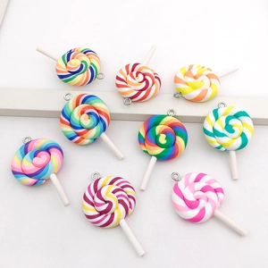 Macro shot of colorful resin spiral lollipop charms with metal rings for DIY jewelry