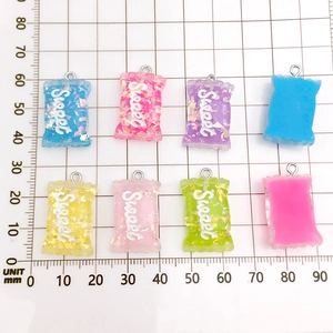 Macro shot of colorful resin candy pendants with Sweet lettering and silver metal loops