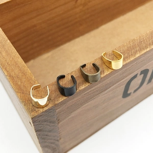 Vue macro de quatre clips d'oreilles en métal en forme de U sur une boîte en bois