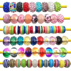 Macro view showing colorful DIY resin beads with stripes and rhinestones for charm bracelets
