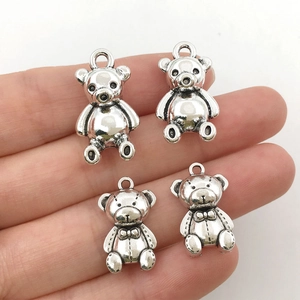 Detailed close-up of antique silver alloy teddy bear charms for DIY jewelry making