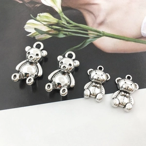 Detail of silver bear charms for DIY jewelry making in various sizes on flat background