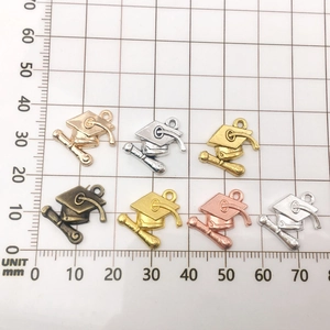 Detailed size view of alloy graduation cap charms showing 20mm width on measurement grid